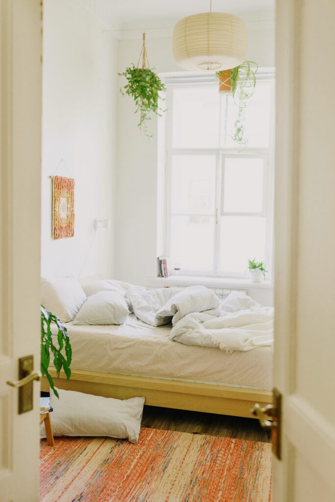 A cozy bedroom featuring a bed, a rug, and a window, creating a serene and inviting atmosphere.